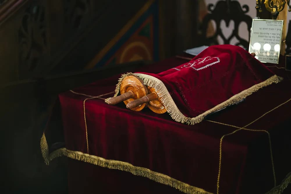 Rouleaux de la Torah posés sur une table drapée de rouge