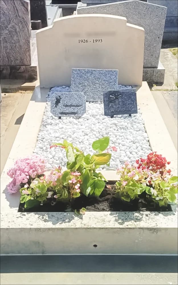 La même sépulture après intervention : pierre éclaircie, gravier ravivé et fleurs replantées