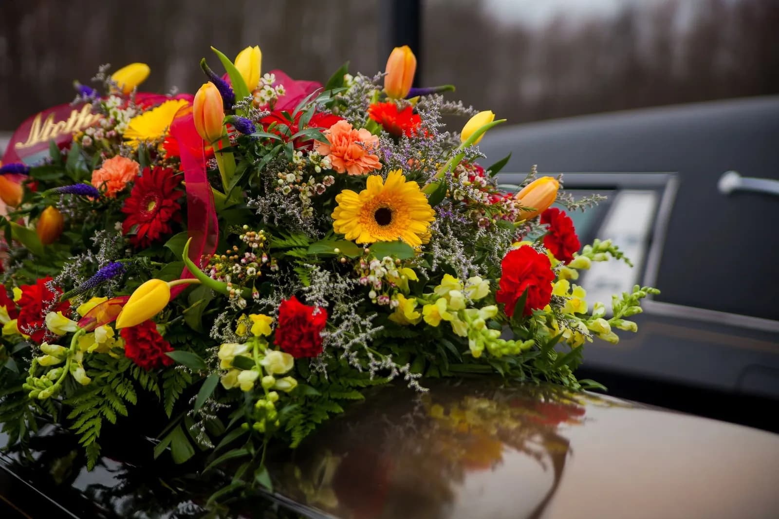 Composition florale posée sur le toit d’un corbillard